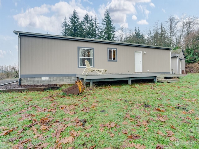 rear view of property featuring a deck and a lawn