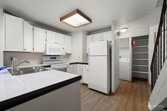1305 W Clearbrook Unit 7, Bellingham, WA 98229 - kitchen with white appliances, washer / dryer, tile countertops, white cabinetry, and light wood-style flooring