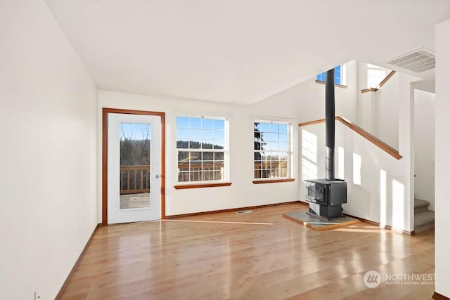 unfurnished living room with a wood stove and light hardwood / wood-style flooring