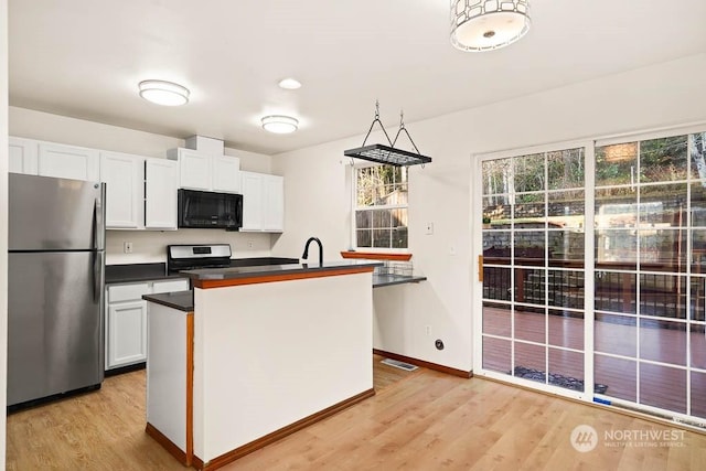 kitchen with stainless steel refrigerator, white cabinets, and light hardwood / wood-style floors