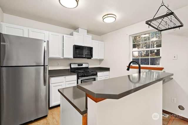 kitchen featuring a center island, white cabinets, sink, light wood-type flooring, and appliances with stainless steel finishes