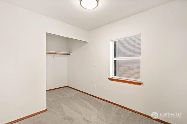 unfurnished bedroom with a closet and light colored carpet