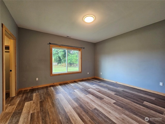 spare room with dark wood-type flooring