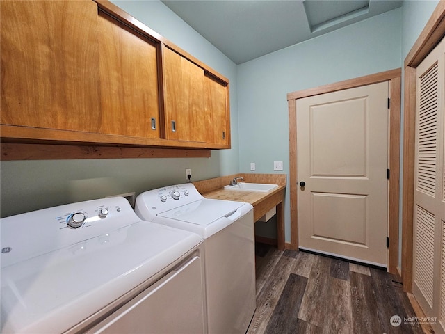 laundry room with dark hardwood / wood-style flooring, washer and dryer, and cabinets