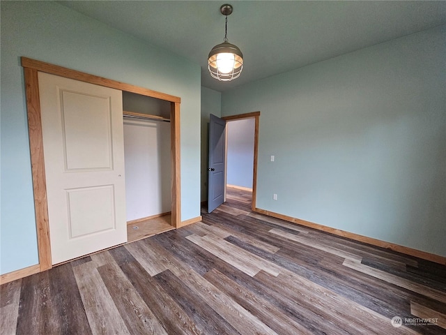 unfurnished bedroom with dark hardwood / wood-style floors and a closet