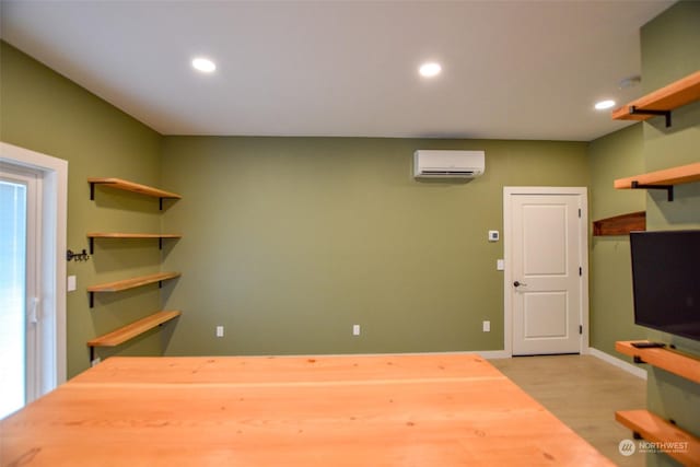 interior space with light hardwood / wood-style floors and an AC wall unit