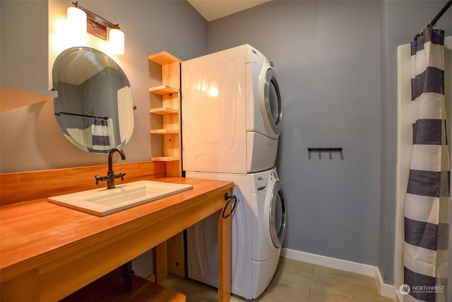 laundry area featuring stacked washing maching and dryer and sink