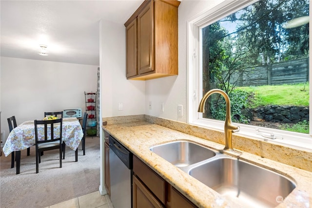 kitchen with dishwasher, sink, light stone counters, and light carpet