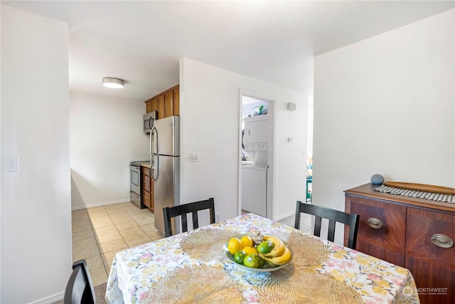 dining area with stacked washer / drying machine and light tile patterned flooring