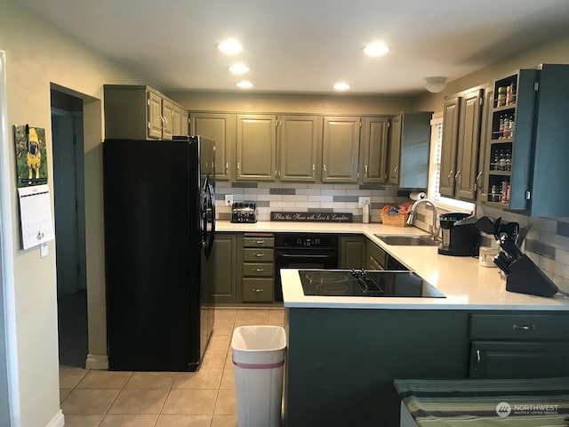 kitchen featuring black appliances, decorative backsplash, kitchen peninsula, and sink