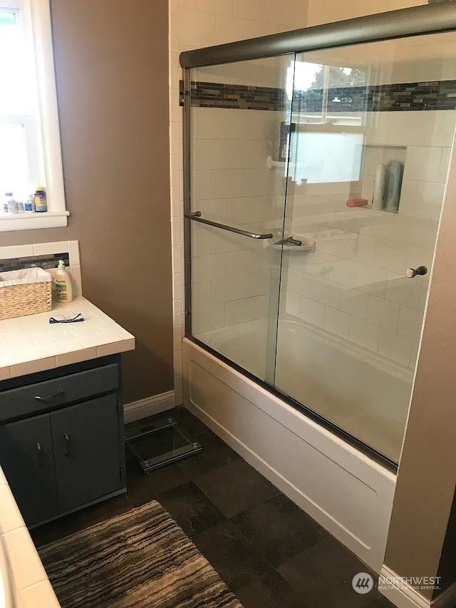 bathroom featuring combined bath / shower with glass door and a healthy amount of sunlight