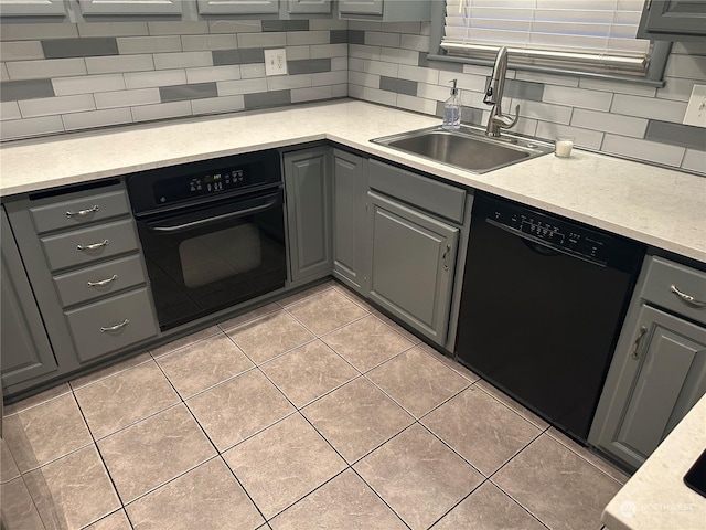 kitchen featuring black appliances, backsplash, gray cabinets, and sink