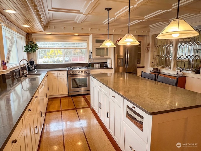 kitchen featuring stainless steel appliances, a kitchen island, hanging light fixtures, and sink