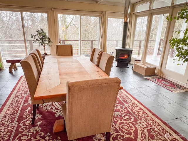 sunroom with a wood stove and a wealth of natural light