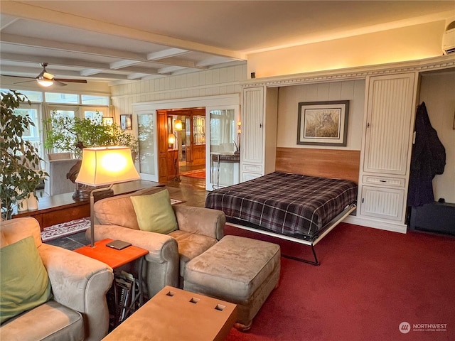 7251 Oak Bay Rd, Port Ludlow, WA 98365 - bedroom featuring an AC wall unit, beam ceiling, wooden walls, and carpet