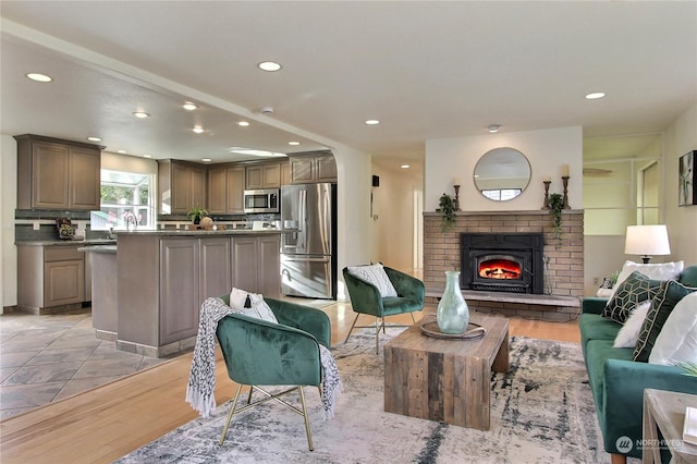 living room featuring light hardwood / wood-style floors and a brick fireplace