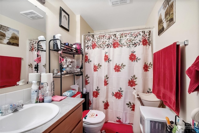 bathroom featuring vanity, toilet, and walk in shower