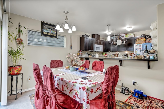 carpeted dining space with a chandelier