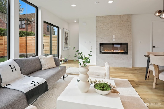 living room featuring light wood-type flooring and a tile fireplace