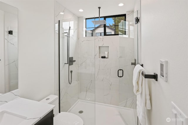 bathroom with toilet, an enclosed shower, and vanity