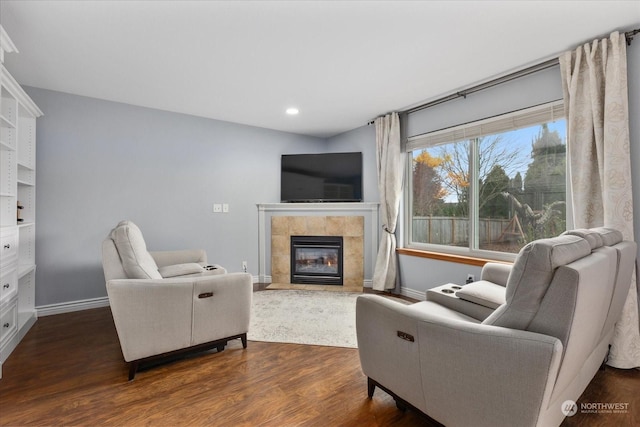 living room with dark hardwood / wood-style floors and a tiled fireplace