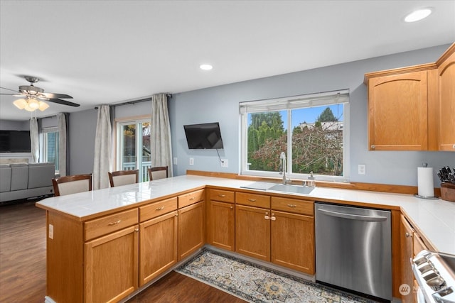 kitchen featuring tile counters, sink, stainless steel dishwasher, dark hardwood / wood-style floors, and kitchen peninsula