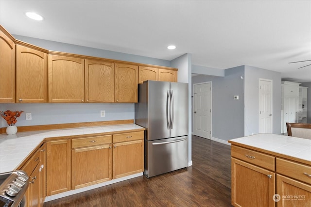 kitchen with tile countertops, stainless steel appliances, ceiling fan, and dark wood-type flooring