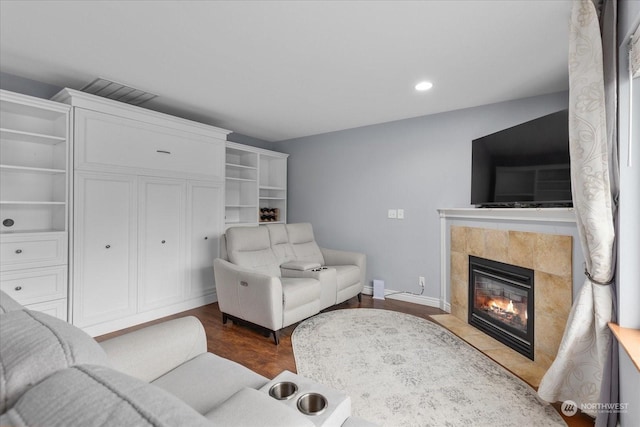 living room with a fireplace and dark wood-type flooring