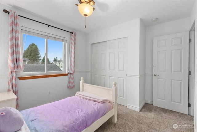 carpeted bedroom with ceiling fan and a closet