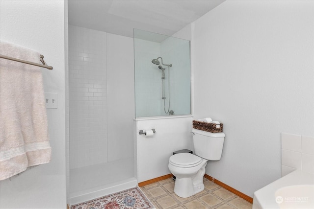 bathroom with tile patterned floors, sink, toilet, and tiled shower