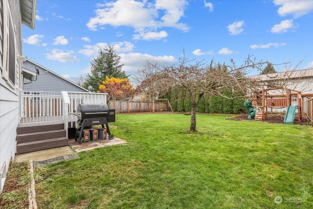 view of yard featuring a deck and a playground