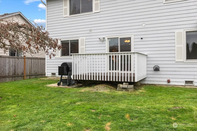 back of property featuring a wooden deck and a yard