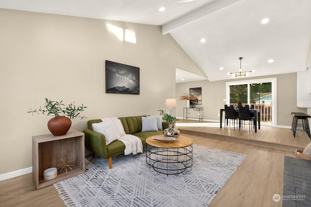 living room featuring a chandelier, lofted ceiling with beams, and light hardwood / wood-style flooring