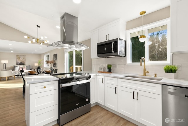 kitchen featuring decorative light fixtures, island range hood, sink, and appliances with stainless steel finishes