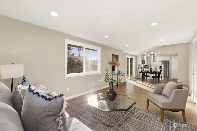 living room with hardwood / wood-style floors and an inviting chandelier