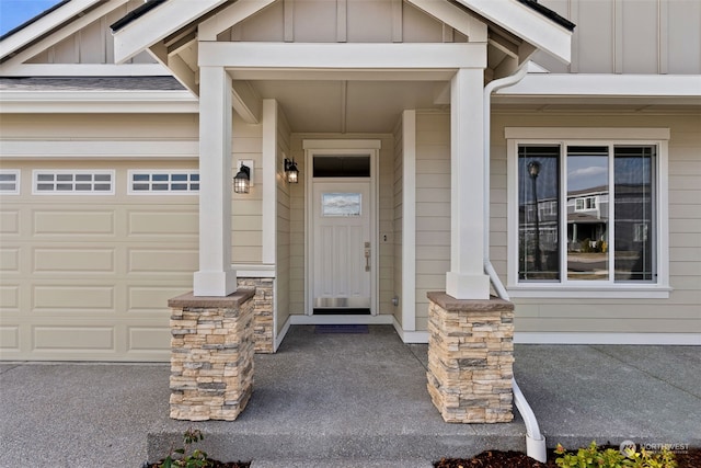 view of exterior entry with a porch, board and batten siding, and an attached garage