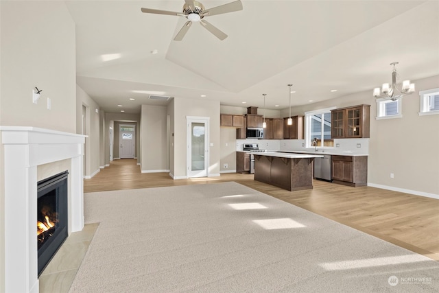 kitchen featuring hanging light fixtures, light hardwood / wood-style flooring, stainless steel appliances, and a kitchen island