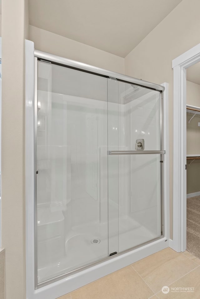 bathroom with tile patterned flooring and a shower with shower door