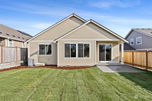 back of house with cooling unit, a yard, and a patio