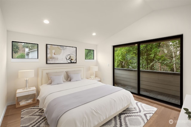 bedroom featuring light hardwood / wood-style floors, access to exterior, and vaulted ceiling