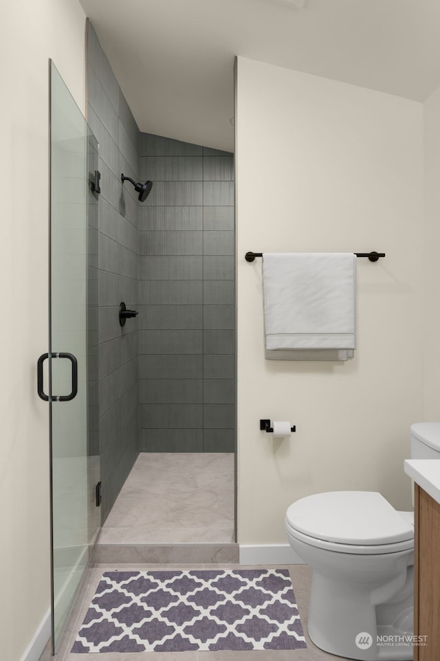 bathroom with a shower with door, vanity, vaulted ceiling, and toilet