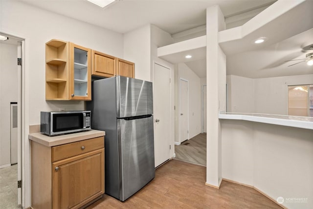 kitchen featuring appliances with stainless steel finishes, light hardwood / wood-style floors, and ceiling fan