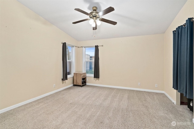 carpeted spare room featuring ceiling fan and lofted ceiling