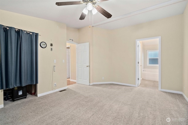 unfurnished bedroom with ensuite bath, ceiling fan, and light carpet