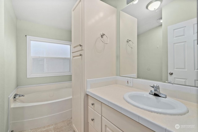 bathroom with tile patterned flooring, vanity, and a tub