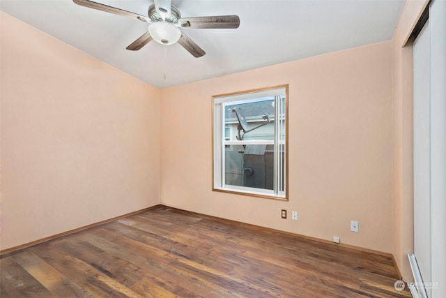 spare room featuring ceiling fan and dark wood-type flooring