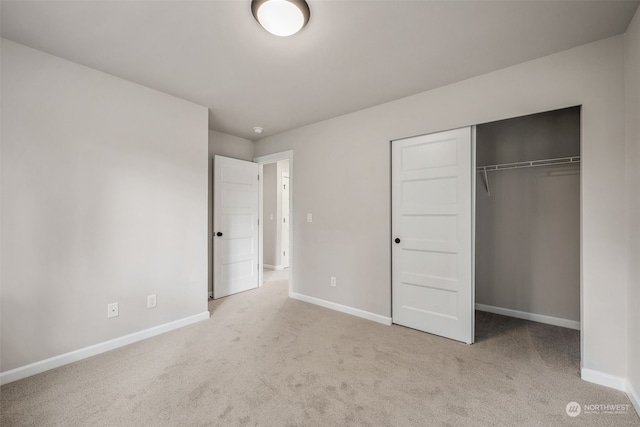 unfurnished bedroom featuring light colored carpet and a closet