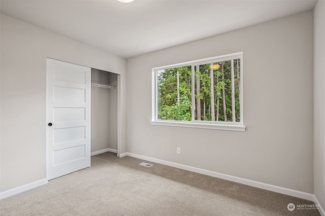 unfurnished bedroom featuring carpet floors and a closet