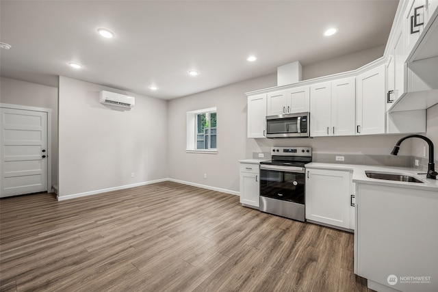 kitchen featuring white cabinetry, sink, light wood-type flooring, and appliances with stainless steel finishes