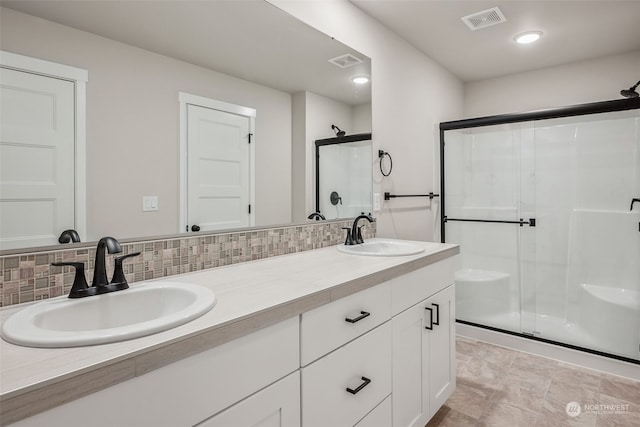 bathroom with vanity, backsplash, and walk in shower